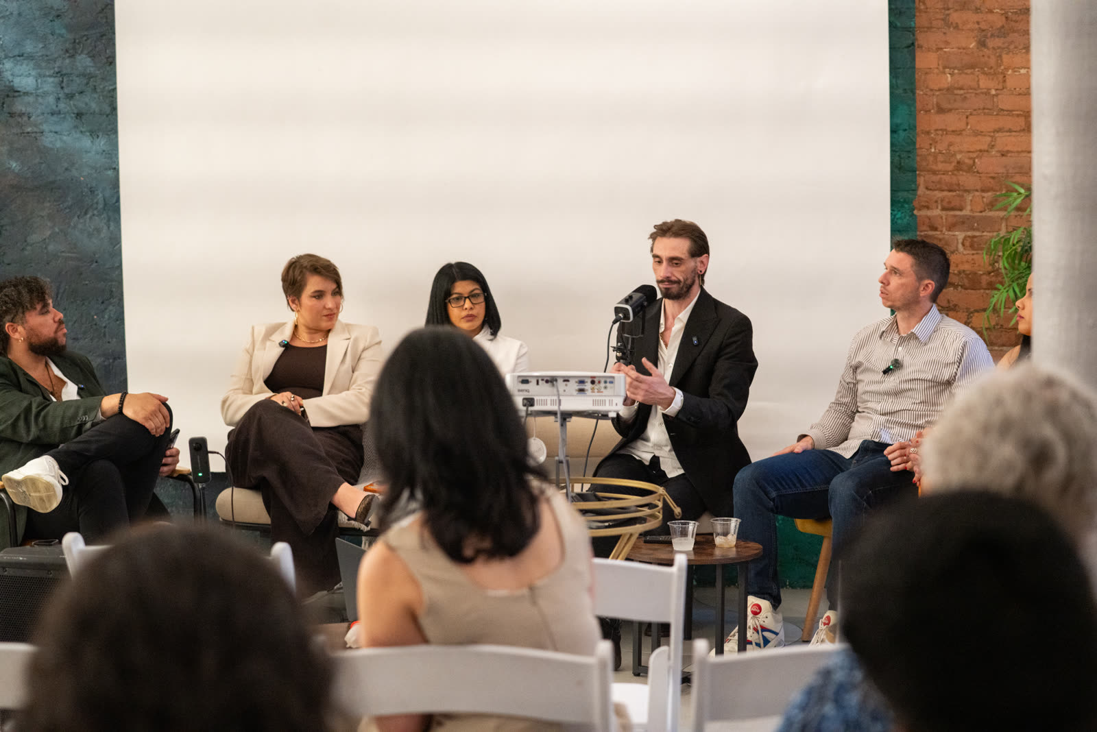 Speakers on the Impact Room stage with event branding in the background